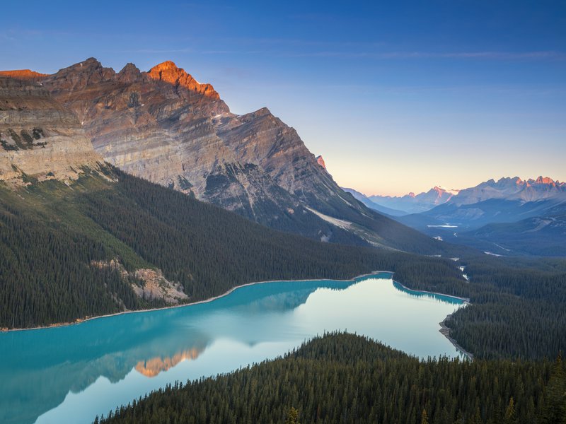 Lake at dawn with sun setting over mountains
